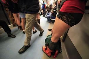 A man walks between passengers without pants inside a subway train during "The No Pants Subway Ride" in Bucharest