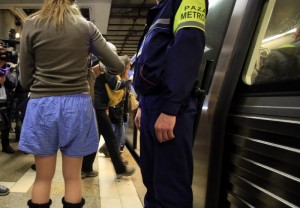 A participant stands next to a subway guard during "The No Pants Subway Ride" in Bucharest