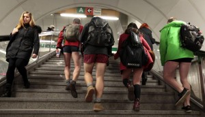 Passengers not wearing pants walk up the stairs through a subway train transfer tunnel  during the "No Pants Subway Ride" in Prague